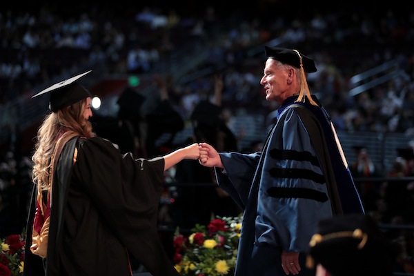 Geoff Garrett congratulates a new graduate at USC Marshall Commencement 2022